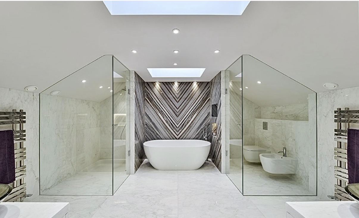 Marble bathroom with freestanding bath under a skylight