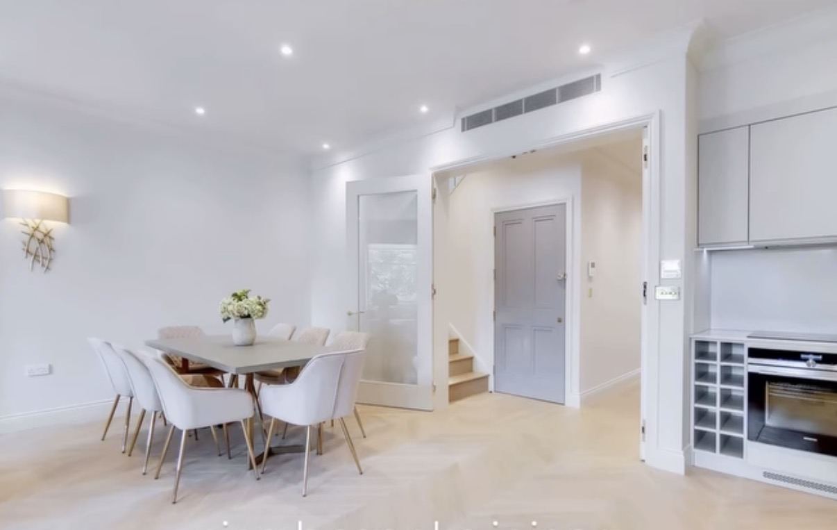 Dining area with oval table beside the hallway