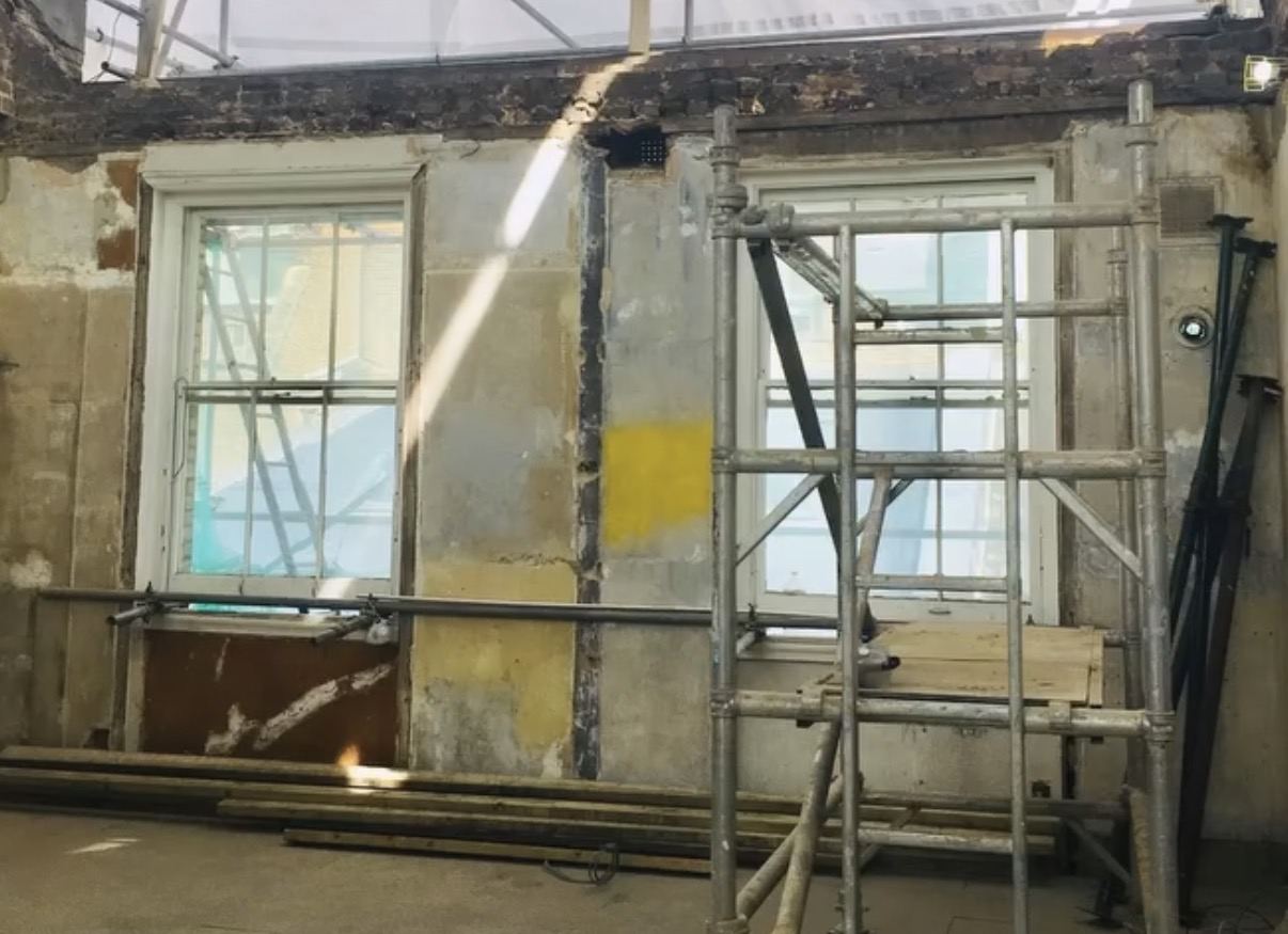 Strip-out: walls opened up to the brickwork with scaffold tower inside