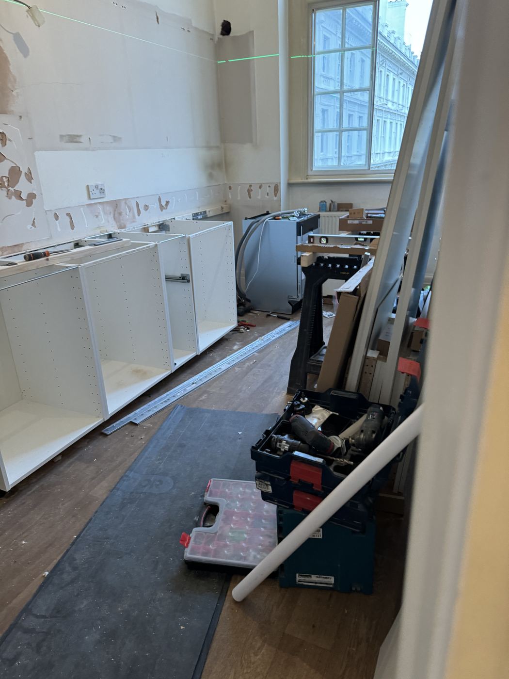Kitchen during installation with carcasses fitted and tools on the floor