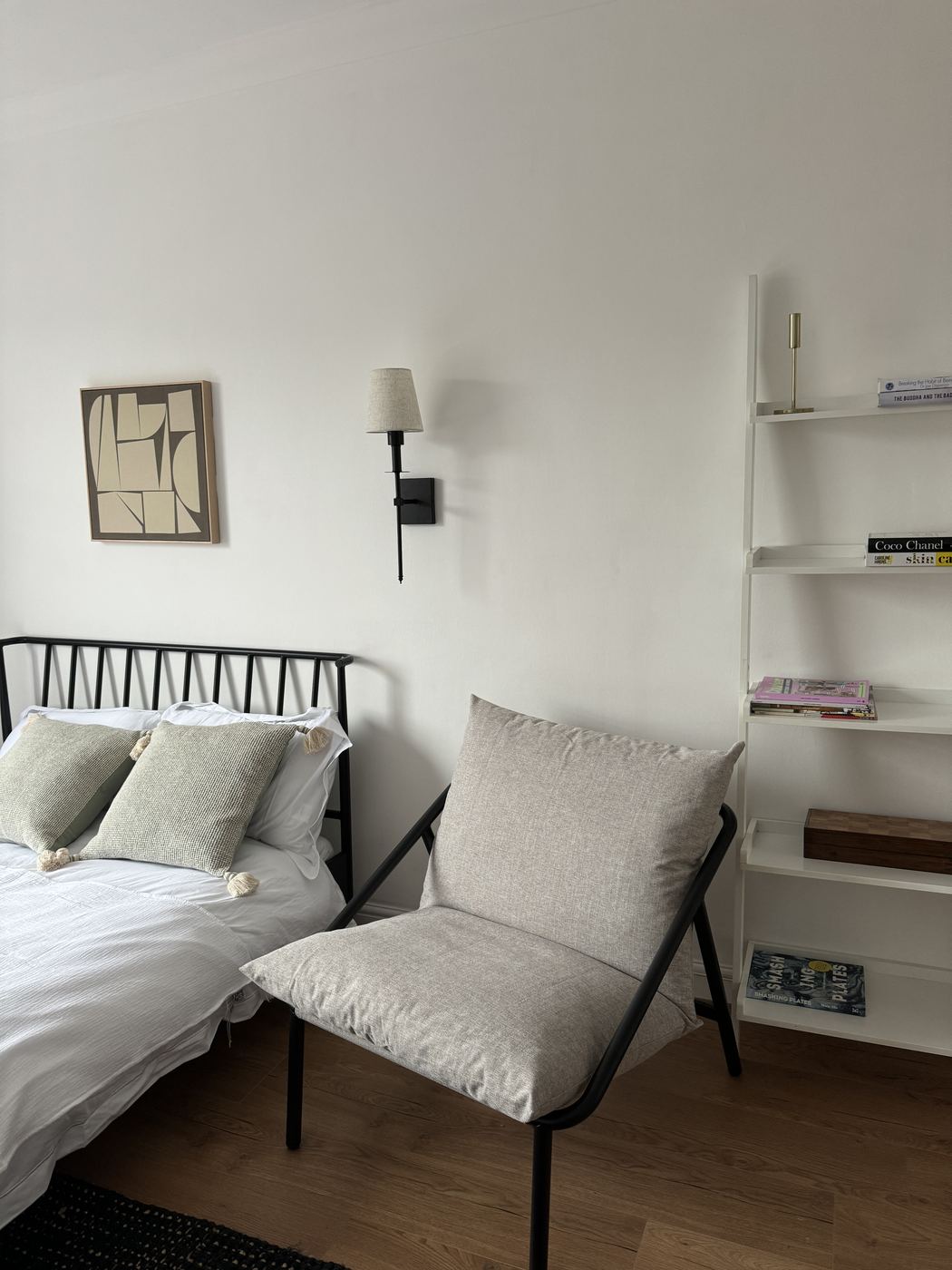 Styled bedroom with linen bedding, armchair and wall light